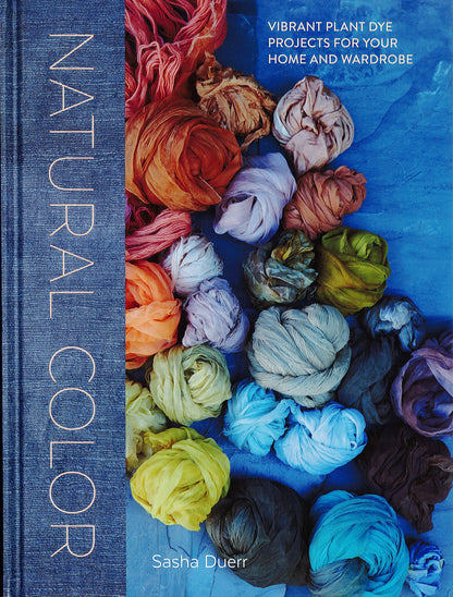 The cover of "Natural Color" by Sasha Duerr, published by Penguin Random House, features a visually striking arrangement of sustainably dyed textiles in vibrant colors against a blue background. The subtitle reads, "Vibrant Plant Dye Projects for Your Home and Wardrobe.