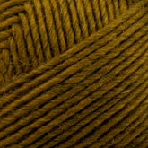 Close-up image of a ball of mustard yellow Lamb's Pride Worsted Yarn by Brown Sheep. The strands are neatly wound, creating a textured pattern. The fibers are slightly fuzzy, ideal for Navajo style weaving or felting projects, adding a soft and artisanal touch.