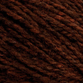 Close-up image of Harrisville Designs' Harrisville Shetland Yarn - Unwashed Cones. The strands are tightly spun together, showcasing a blend of dark and lighter brown fibers reminiscent of classic Fair Isle knitting designs, creating a rich, earthy look. The image highlights the yarn's thickness and fibrous details.