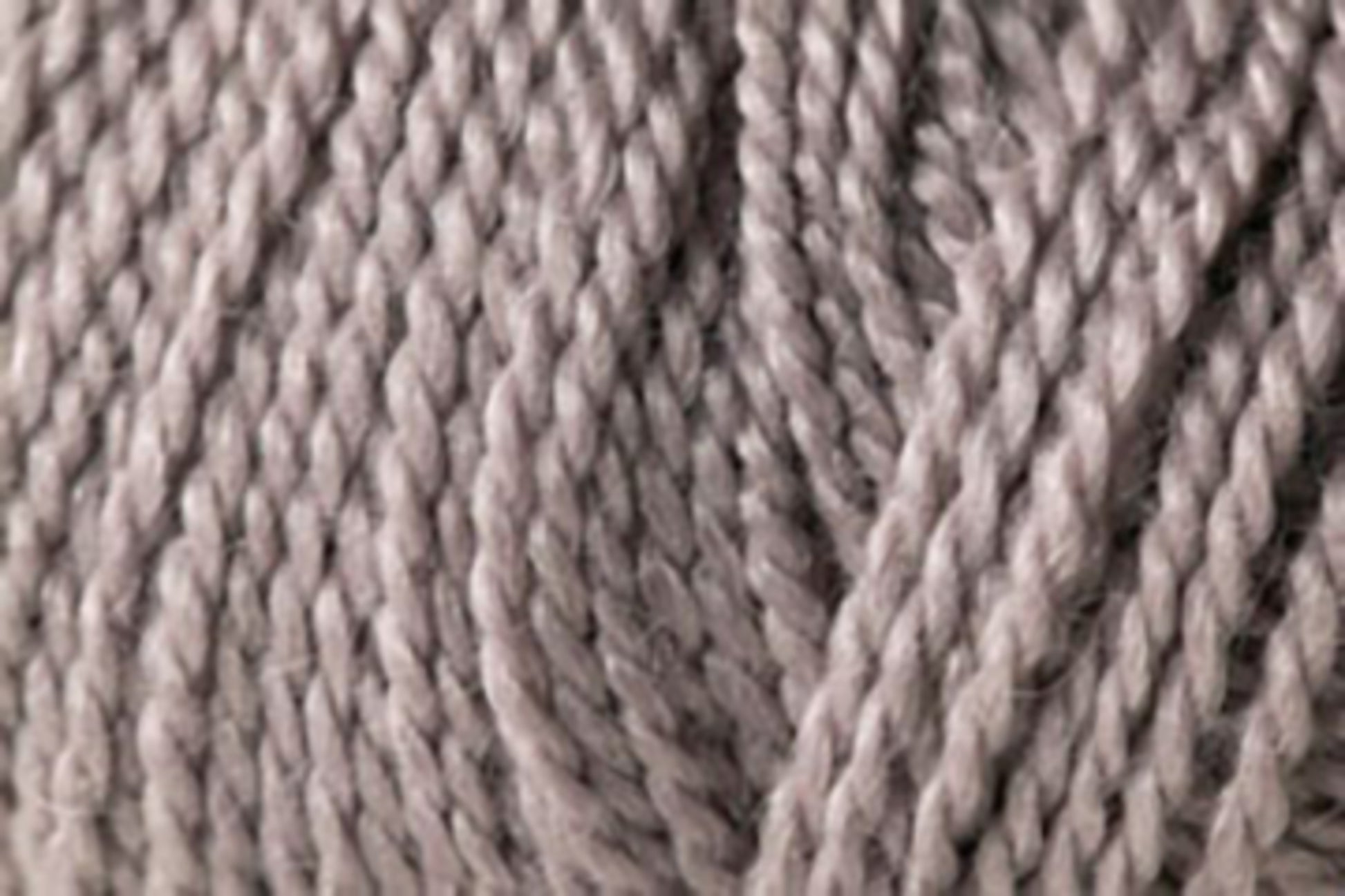 Close-up view of a skein of Kingfisher Yarn & Fibre's Jo Sharp Alpaca Kid Lustre in grey, showcasing tightly twisted strands and the soft, smooth texture characteristic of this DK gauge yarn.