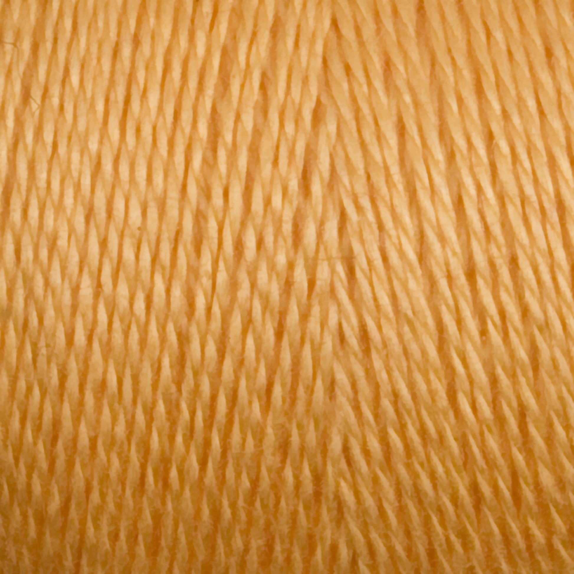 Close-up view of a spool of golden yellow 8/2 Tencel Yarn from Maurice Brassard. The threads are tightly wound in a crisscross pattern, creating a textured appearance. The smooth, shiny thread indicates the soft quality typical of Tencel yarn. Perfect for vibrant and warm knitting accessories or weaving projects.