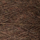 Close-up image of a ball of JaggerSpun Heather 3/8 wool yarn from Jagger Brothers, Inc., featuring a mix of earthy colors including shades of brown, green, and hints of orange. The texture appears slightly rough and fibrous, showcasing the individual strands of yarn intertwined together.