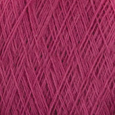 Close-up of pink JaggerSpun Maine Line 2/20 Yarn by Jagger Brothers, Inc., woven in a crisscross pattern. The texture of the medium-grade wool is visible, with individual fibers and threads interlaced to form a dense, intricate mesh. The overall appearance is soft and slightly fuzzy.