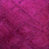 Close-up view of Caledonian Dye Works' Victorian Brushed Mohair Yarn in a vibrant magenta color, featuring a fluffy, fibrous texture that resembles luxurious mohair or soft, loosely tangled Victorian yarns. The intricate web of threads in the Mini Skein gives the image a warm and tactile appearance.