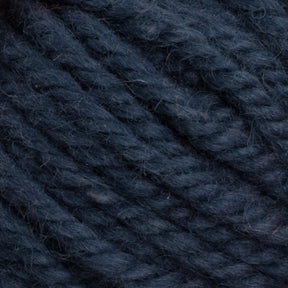 Close-up image of Halcyon Yarn Classic Rug Wool in dark navy blue by Caledonian Dye Works. The texture is coarse and slightly fuzzy, with individual strands twisted tightly together. This high-quality strand is perfect for rug weavers seeking durable material.