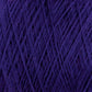 Close-up view of a tightly wound ball of purple JaggerSpun Maine Line 3/8 Yarn | Mini-cone by Jagger Brothers, Inc., showcasing the interwoven texture and fibers. The worsted spun yarn appears soft and thick, suitable for knitting or crocheting. The image highlights the intricate, crisscrossed pattern created by the strands.