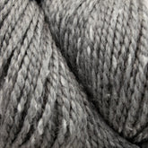 Close-up of a skein of Acadia by The Fiber Company in thick, grey hues with faint speckles of white, creating a subtle tweed effect. The texture appears soft and slightly fuzzy, with tightly twisted strands. The image highlights the yarn's fibrous and cozy appearance, suitable for knitting or crocheting. This luxurious yarn is brought to you by The Fibre Co. (UK) Ltd.