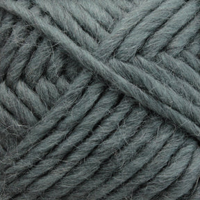 Close-up of a ball of **Lamb's Pride Bulky Yarn** by **Brown Sheep** featuring a soft, woolly texture in a muted sea green color. The individual strands are thick and loosely wound together, making it perfect for knitters and crocheters looking to craft warm Icelandic sweaters or cozy woven blankets.