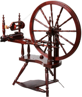 The Kromski Polonaise Spinning Wheel by Kromski North America is expertly crafted from European alder and birch and features a large wheel, spindle, and foot pedal. Its intricate design includes several turned wood elements with double drive and Scotch tensioning. The polished finish enhances its antique appearance, making it perfect for spinning fibers into yarn.