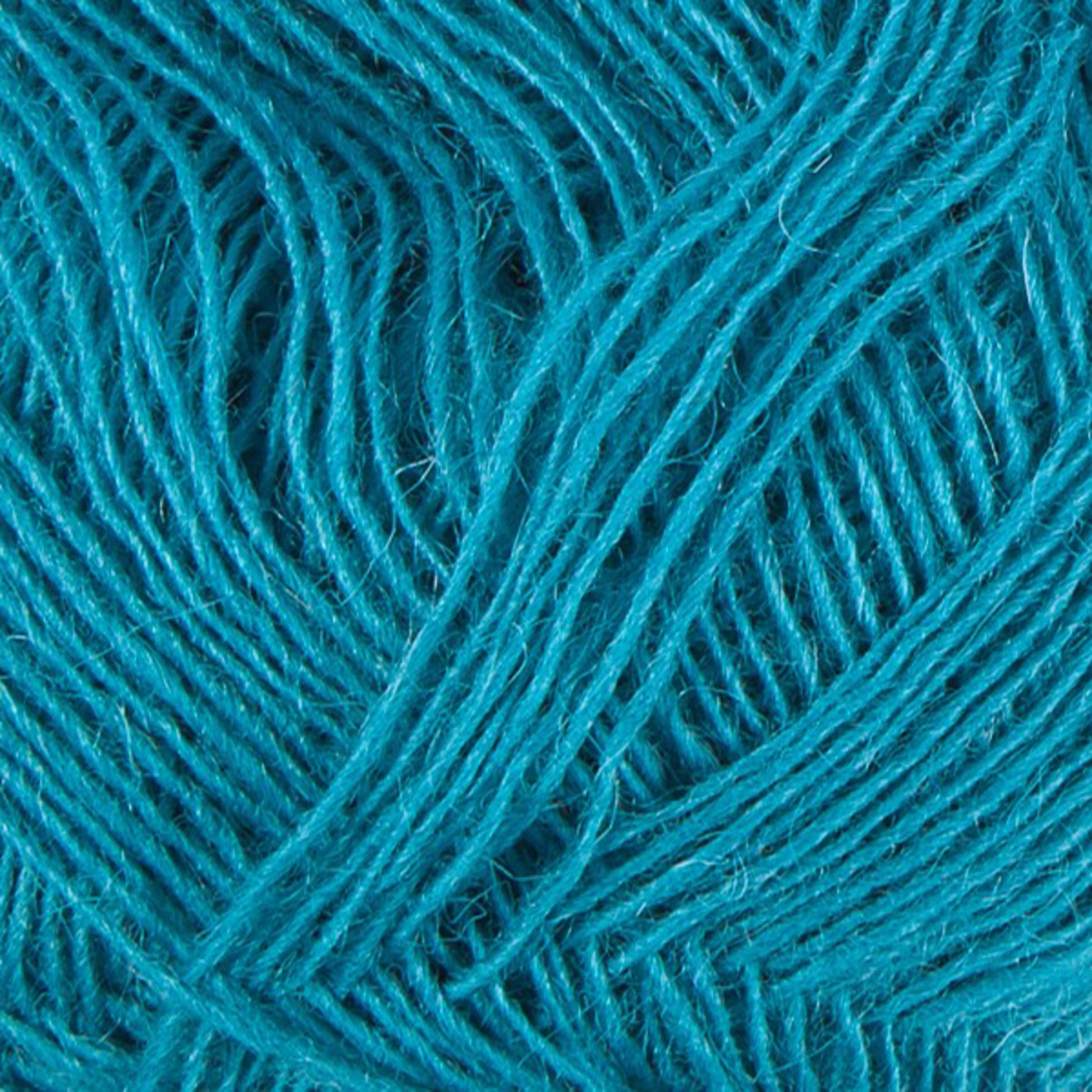 Close-up image of a ball of turquoise Einband Lopi yarn by Berroco, Inc., showing intricate textures and strands intertwined in a crisscross pattern. The fibers, reminiscent of delicate lace knitting, are soft and slightly fuzzy, capturing light and shadow within the weave.