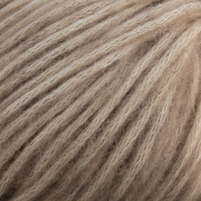 Close-up image of a ball of soft, beige-colored Katia Cotton-Merino yarn by Knitting Fever / Euro Yarns, featuring an aran weight with a smooth and fluffy texture. The strands are loosely wound together, creating a cozy and inviting appearance.