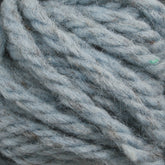 Close-up image of Halcyon Yarn Classic Rug Wool | Skein by Caledonian Dye Works in light blue, hand-dyed with visible fibers, tightly wound together.