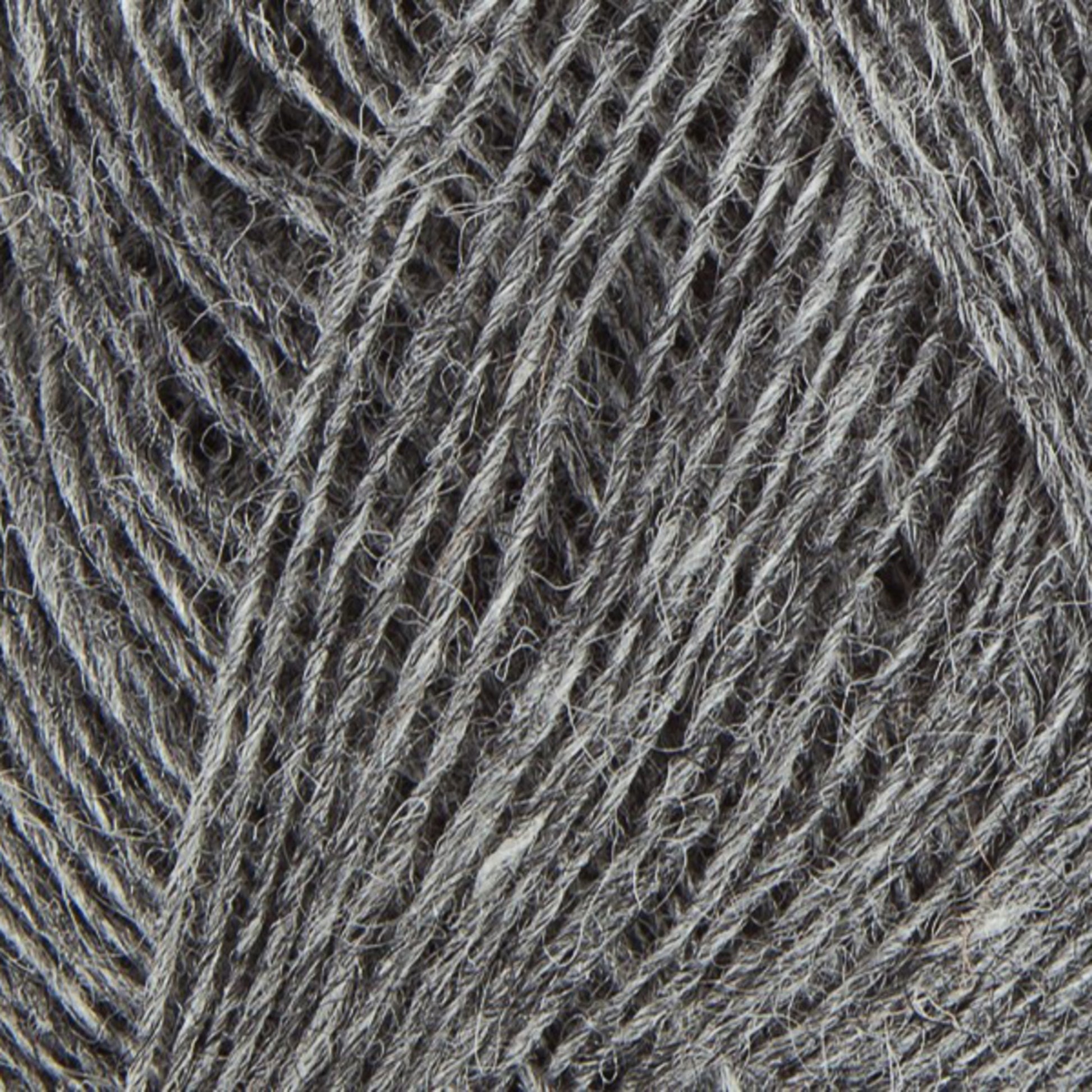 A close-up image of Einband Lopi by Berroco, Inc. displays its grey yarn with intricately intertwined fibers and a textured surface. The Icelandic wool looks soft and slightly fuzzy, showcasing various shades of grey that lend a variegated appearance. Ideal for lace knitting projects.