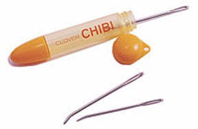 The image shows a Bryson Distributing, Inc. Chibi Bent Tapestry 3 Needle Set with its cap removed. The holder is cylindrical with an orange cap and end. Two easy-to-thread tapestry needles lie next to the holder, showcasing its storage capability and practicality for any sewing project.