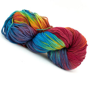 A skein of Great Adirondack Organic DK Cotton from Great Adirondack Yarn Co, Inc. features a vibrant blend of red, blue, green, yellow, and purple hues coiled into a neat twist. This multicolored, hand-dyed organic cotton yarn appears soft and finely spun with variegated colors, perfect for knitting or crocheting projects.