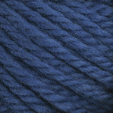 Close-up image of Halcyon Yarn Classic Rug Wool Skein from Caledonian Dye Works, featuring thick, textured yarn in a rich navy blue color. The hand-dye process enhances the yarn's deep hue. The twisted and tightly woven strands emphasize their fibrous texture and slightly fuzzy appearance, ideal for skilled weavers crafting exquisite masterpieces.