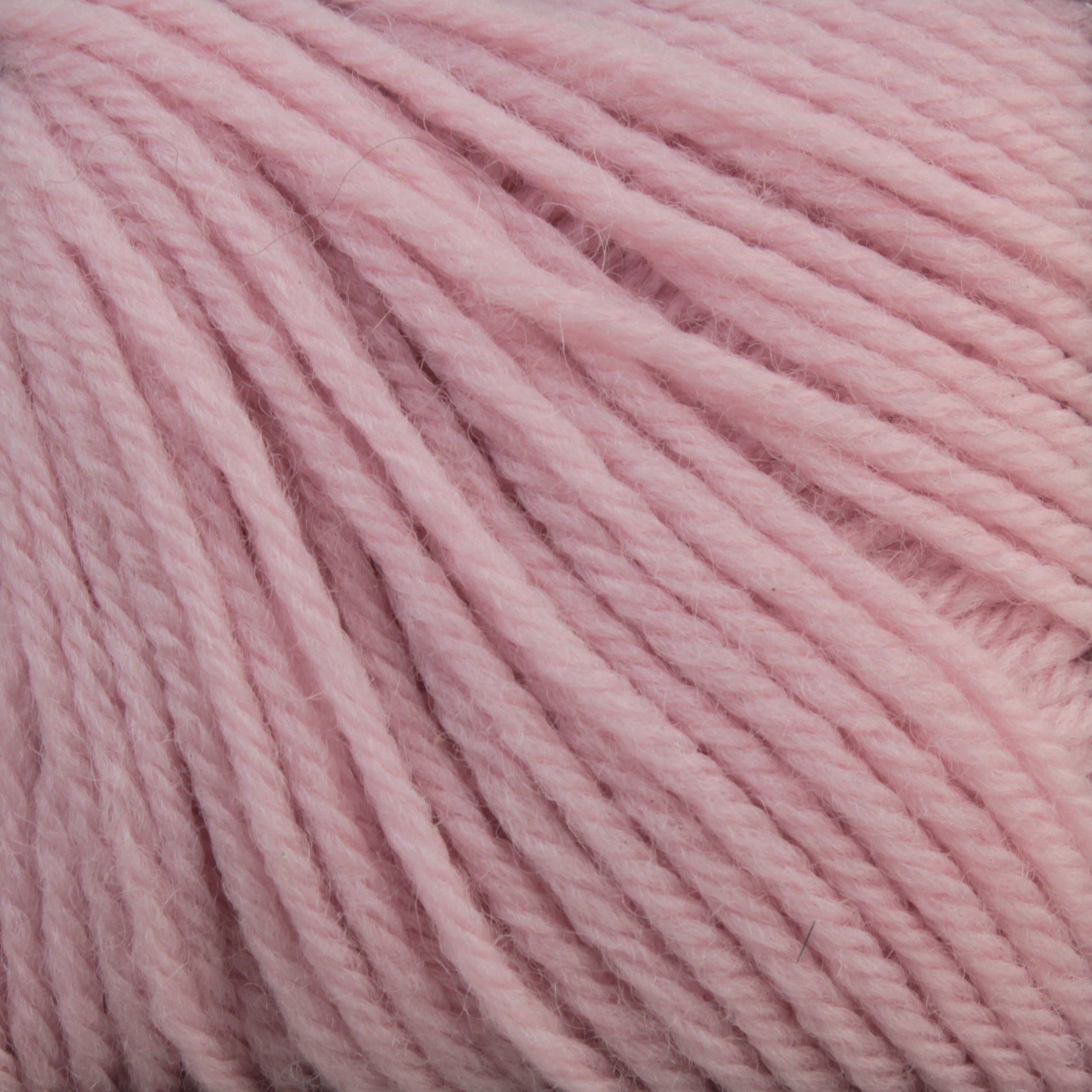 Close-up photo of Baby Blatt by Anny Blatt. This soft, thick yarn in a pale pink hue features slightly fuzzy strands and a clearly visible twist. Offered by Essentially Felt Studio & Fine Yarn, this machine washable baby yarn appears cozy and smooth, making it ideal for knitting or crocheting warm garments and accessories.