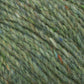 Close-up image of Harrisville Designs' Peace Fleece Yarn showing intertwined fibers in diverse shades of green, accented with flecks of orange, blue, and yellow. The soft and fuzzy texture suggests a blend of wool and mohair, ideal for worsted weight knitting projects.