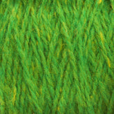 Close-up of bright green yarn. The texture is soft and fuzzy, with intertwining fibers creating a dense, woven pattern. Slight variations in green shades are visible, giving depth and vibrancy to the Harrisville Designs Shetland Yarn - Unwashed Cones, perfect for lightweight blankets or intricate Fair Isle knitting designs.