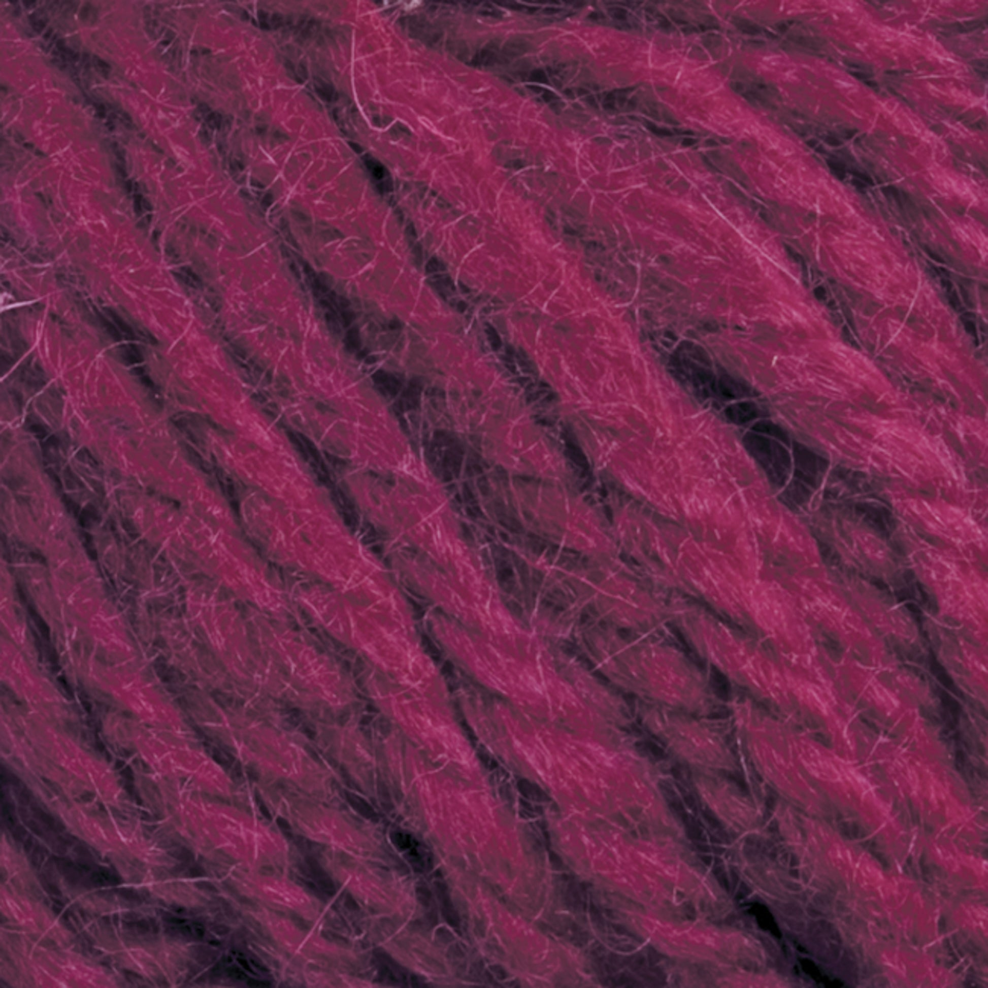 Close-up image of thick, deep magenta Halcyon Yarn Classic Rug Wool by Caledonian Dye Works with a slightly fuzzy texture. The strands are tightly twisted, showcasing a rich, vibrant color ideal for knitting or crocheting. Perfect for rug weavers, this hand-dyed yarn adds a touch of elegance to any project.