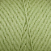 Close-up of Maurice Brassard Cotton 8/8 Carpet Warp in light green, unmercerized cotton. The soft texture is tightly wound into a ball, with visible strands running parallel and crossing at the center. The consistent color is ideal for knitting and crochet projects.