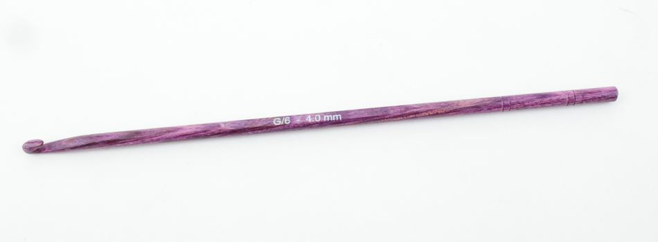 A purple crochet hook, size "G/6 4.0 mm," is displayed on a plain white background. The handcrafted Knitter's Pride Symfonie Dreamz Wooden Crochet Hook from Accessories Unlimited features a smooth, polished finish.