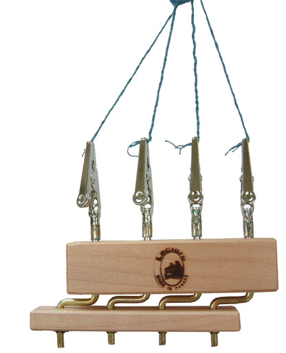 The Leclerc Quad Fringe Twister by Leclerc Looms is a wooden block adorned with a logo and features four adjustable metal clips attached on top using strings. The block also has three brass hooks on the bottom for hanging additional items. The strings on the top are tied together to form a loop, allowing for convenient hanging of the entire device.