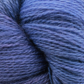 A close-up image of Jade Sapphire Cashmere 2-Ply yarn from Jade Sapphire Exotic Fibres showcases its soft, fluffy texture in a range of hand-dyed blue shades, from light to dark. The thick and cozy fibers are visibly individual, exuding a sense of warmth and comfort ideal for creating finely knit sweaters.