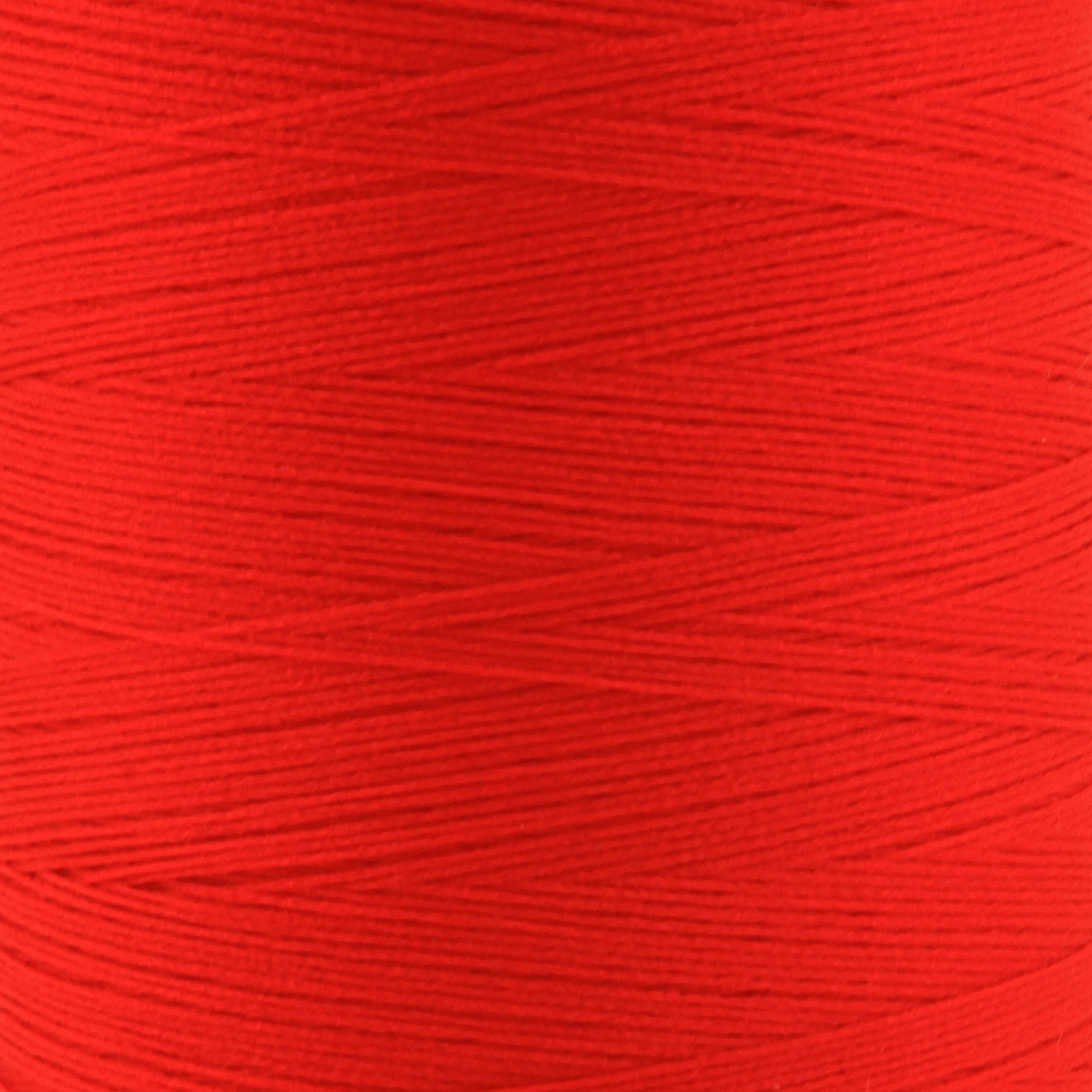 A close-up of a spool of bright red Woolly Nylon Reinforcement Yarn by YLI Corp., showing the fine strands wound tightly in a diagonal pattern. The texture and color are vibrant, giving a detailed view of the yarn's surface—ideal for crafting durable socks.