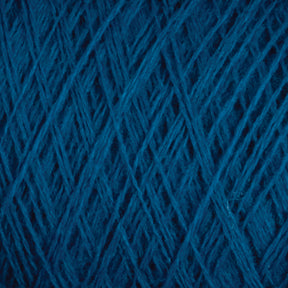 Close-up of tightly wound JaggerSpun Maine Line 3/8 Yarn | Large Cone from Jagger Brothers, Inc., showing the intricate crisscross pattern of the threads. The texture is soft and fibrous, with subtle variations in the hue of the blue strands. The image highlights the detailed structure of this soft, medium grade wool.