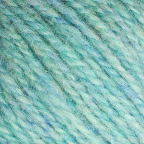 Close-up of a skein of Bartlettyarns' Bartletts Maine Wool - Sport in light turquoise and soft blue hues. The Maine Wool fibers are slightly fuzzy and interwoven, creating a textured appearance. The colors blend smoothly together, giving a calming and soothing effect.