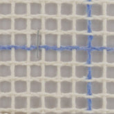 A close-up image of the Fleur de Paris Latch Hook Canvas Rug Backing, measuring 59 inches wide with a grid of 3.75 holes per inch. A silver embroidery needle is threaded through the canvas at the intersection of the blue lines, indicating it's ready for a design transfer. The canvas appears to be used for cross-stitch or needlepoint embroidery.