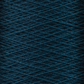 Close-up view of the Supreme Corp. 10/2 Pearl Cotton Yarn | Mini-cone in dark teal, showcasing its detailed, intertwined strands forming a textured pattern. The image highlights the rich colorfastness and intricate crisscrossing arrangement of these versatile fibers.