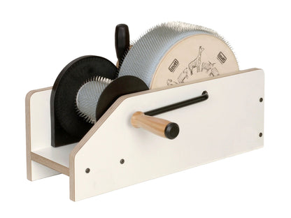 The Louët Inc. Louët 4" Jr Roving Drum Carder is a wooden tabletop device featuring a large drum carder with metal teeth, a hand crank, and a wooden handle. The drum is adorned with animal illustrations on its side and is designed for carding fibers or wool.