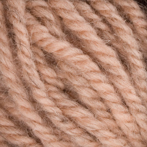 Close-up image of thick, twisted peach-colored yarn. The tightly wound strands of Halcyon Yarn Classic Rug Wool by Caledonian Dye Works give it a soft and textured appearance, perfect for weavers working with hand-dyed Rug Wool.