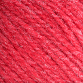 Close-up of Bartlettyarns Maine Wool Yarn with some white fibers woven into the red strands. The texture appears soft and slightly fuzzy, emphasizing the intricate detail, heathered colors, and artisanal quality of the material.