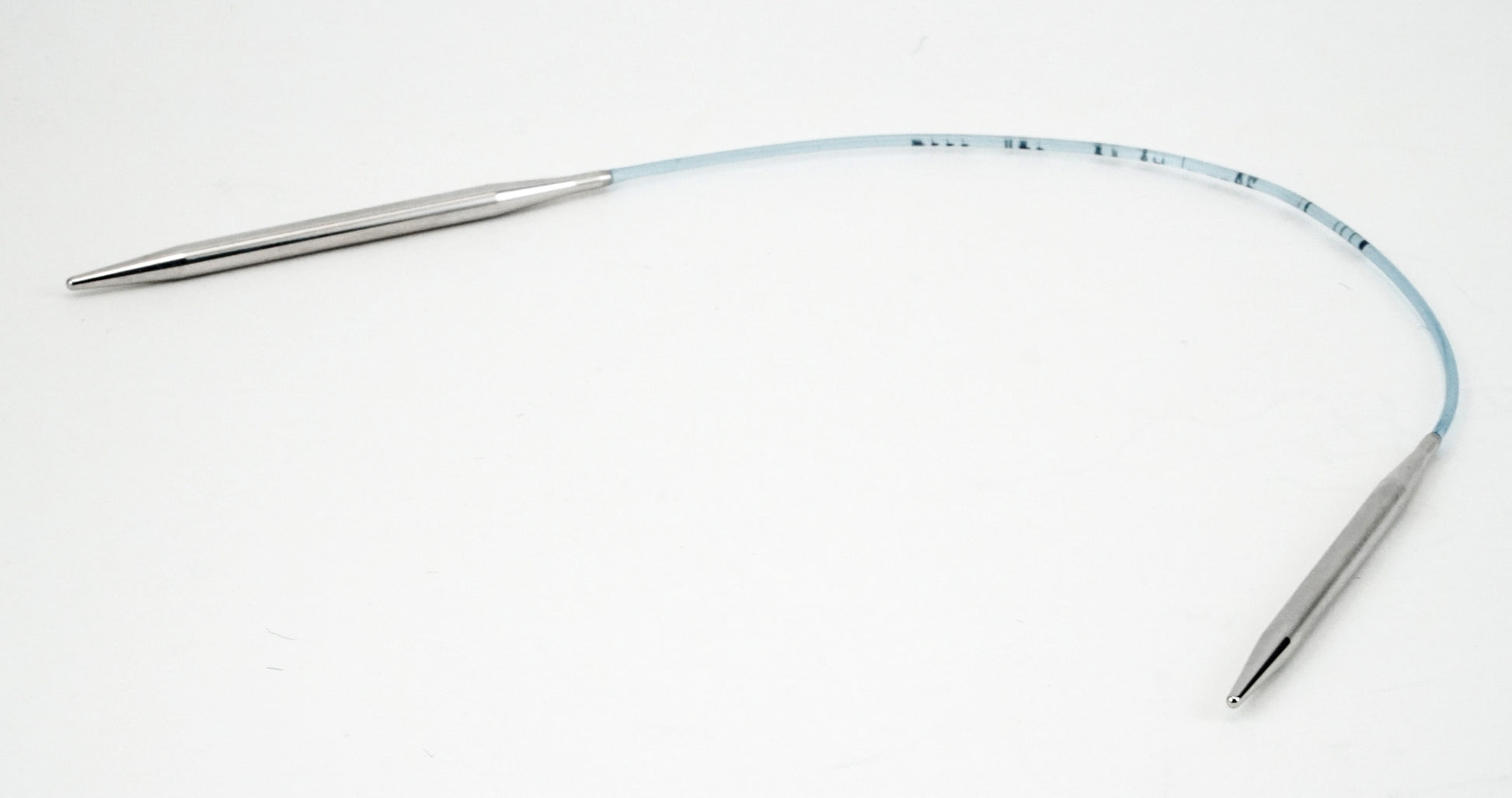 The Addi Turbo Circular Knitting Needles by Skacel feature silver-colored metal tips connected by a flexible, light blue nylon cord with small measurement markings near the tips. Perfect for cuffs, collars, and doll clothes projects, the needle is curved in a wide arch on a plain white background.