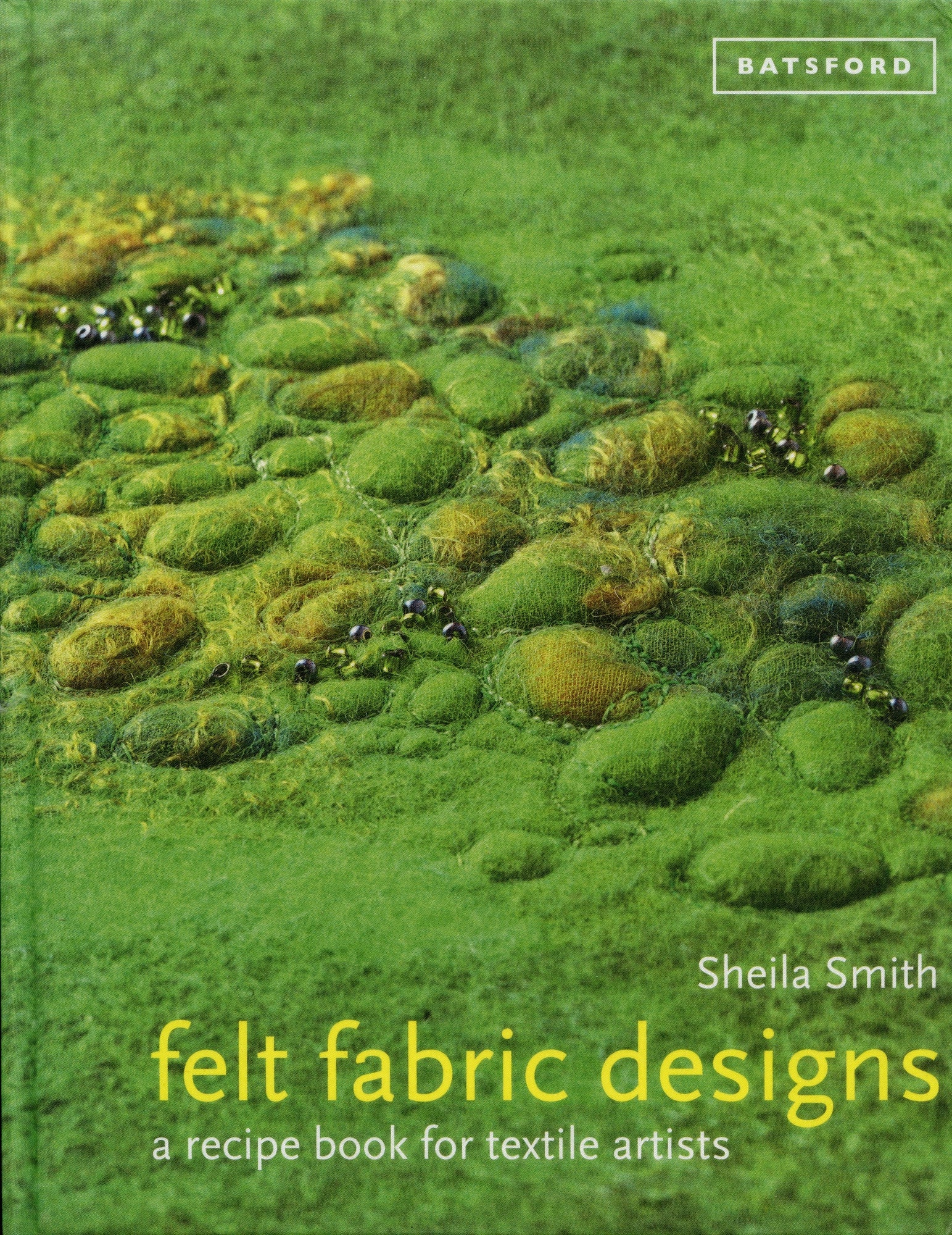 The cover of "Felt Fabric Designs: A Recipe Book for Textile Artists" by Sheila Smith showcases a textured green fabric with felted patterns resembling mossy terrains and stones, highlighting intricate felting techniques. The brand name "Ingram Content" is noted at the top right corner.