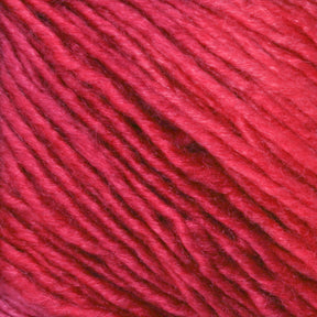 Close-up image of the vibrant red Malabrigo Silky Merino yarn from Malabrigo Yarn, showcasing the texture and twist of the fibers. The yarn appears soft and slightly shiny, indicating a smooth and possibly slightly silky composition. The strands are tightly wound and evenly spaced.