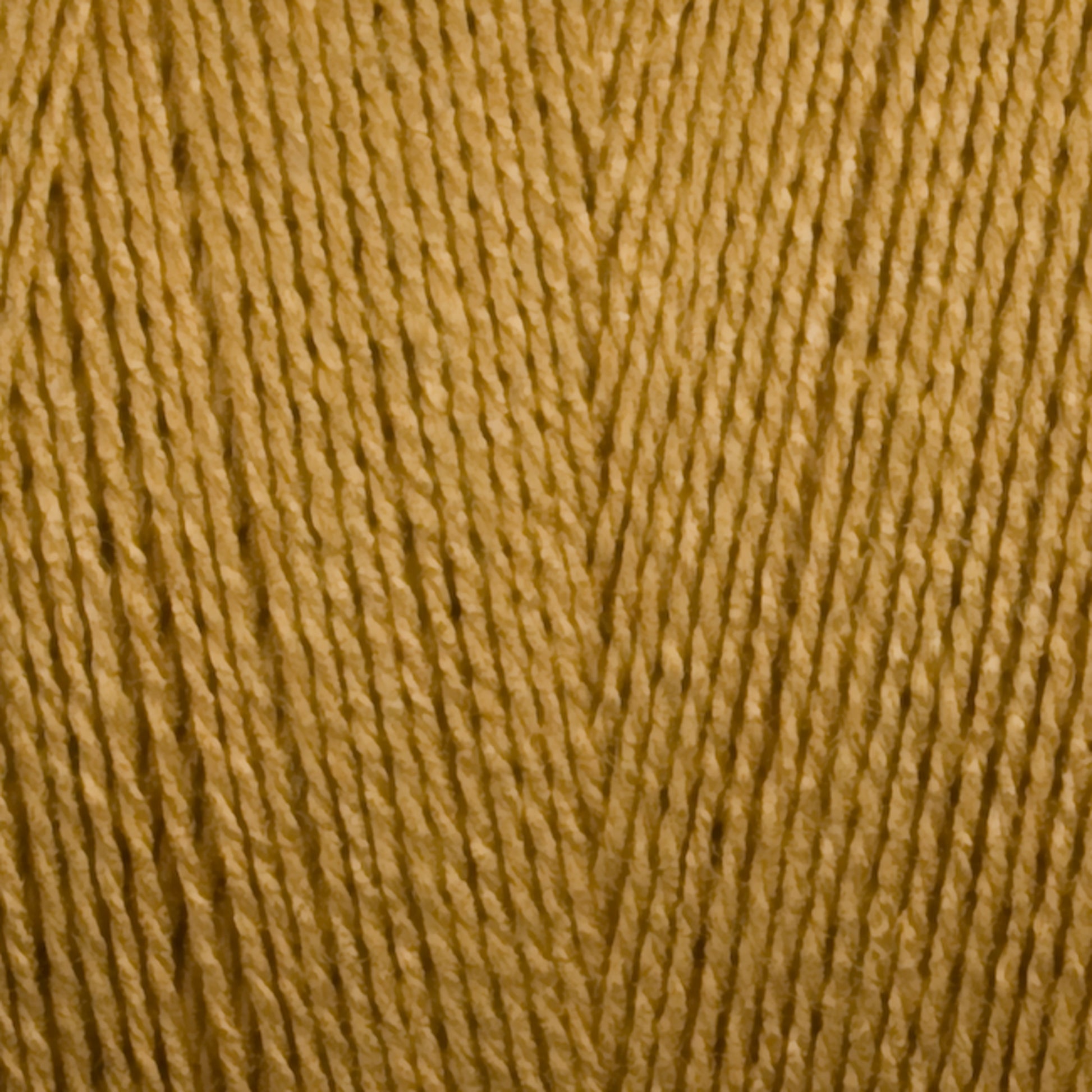 Close-up image of a spool of Maurice Brassard 8/2 Tencel Yarn | Mini Cone in golden yellow, highlighting the texture and tightly wound fibers. This Tencel yarn has a smooth appearance and gives a warm, rich tone, making it perfect for weaving projects or as knitting accessories.