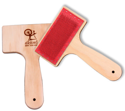 A pair of carders from Ashford Handicrafts Limited, featuring wooden handles with small holes at the end and red carding surfaces outfitted with medium 72 Pts/in stainless steel wire. The back of one carder is engraved with the "Ashford, New Zealand" brand logo.