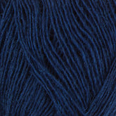 Close-up of Einband Lopi navy blue yarn strands by Berroco, Inc. The image showcases the intertwined fibers exhibiting a rich, deep blue hue with a soft texture, perfect for lace knitting. This detailed view highlights the yarn's thickness and intricate weave pattern.