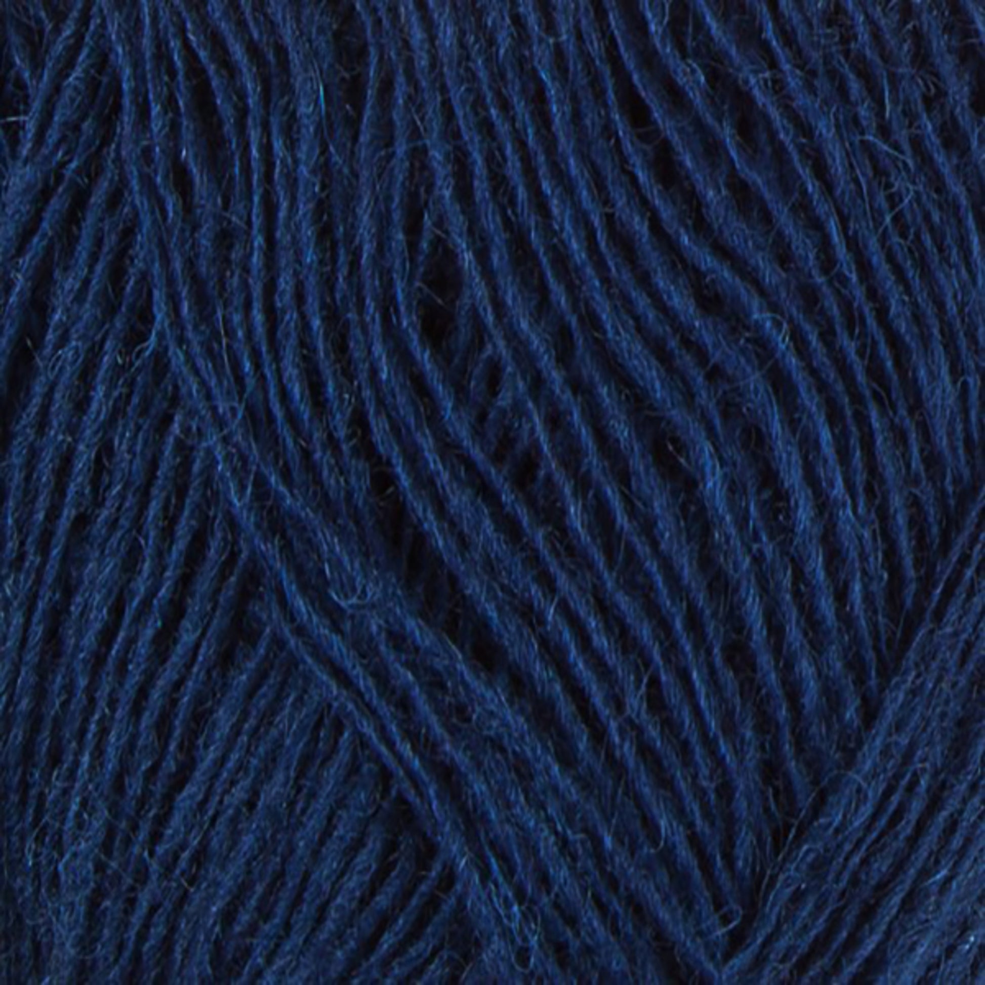 Close-up of Einband Lopi navy blue yarn strands by Berroco, Inc. The image showcases the intertwined fibers exhibiting a rich, deep blue hue with a soft texture, perfect for lace knitting. This detailed view highlights the yarn's thickness and intricate weave pattern.