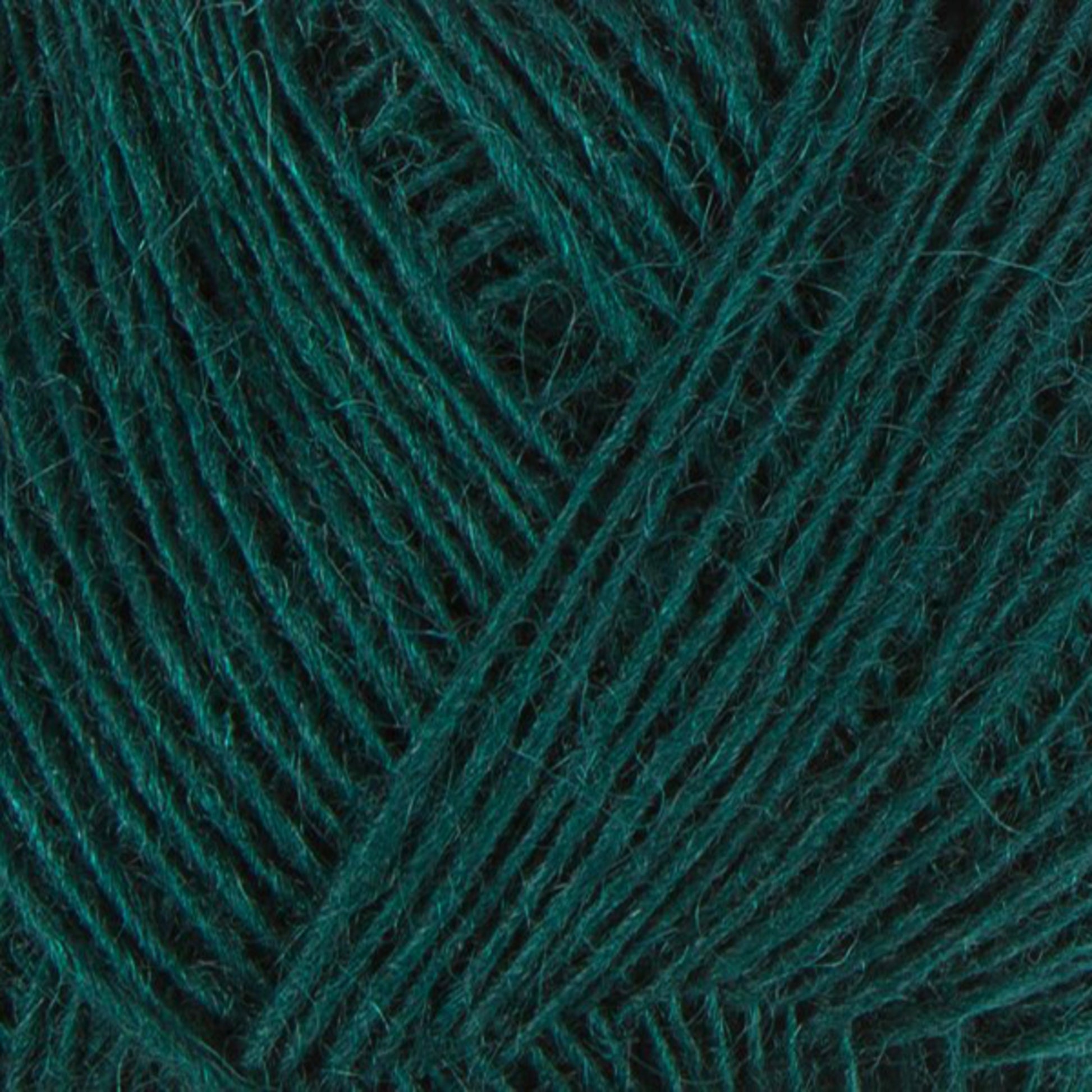 Close-up image of Einband Lopi dark green yarn. The fibers are neatly wound in a crisscross pattern, giving a textured appearance. The soft and slightly fuzzy yarn from Berroco, Inc. is ideal for knitting or crocheting projects, perfect for intricate lace knitting or beautiful stranded colorwork designs.