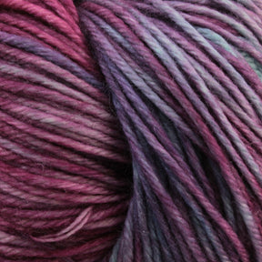 A close-up of Malabrigo Arroyo, a multicolored sport weight superwash merino wool yarn by Malabrigo Yarn, reveals strands in varying shades of purple, pink, and blue. The texture of the fibers is visible, with some areas appearing smoother and others slightly fuzzy. The colors blend seamlessly to create a vibrant and rich appearance perfect for lightweight garments.