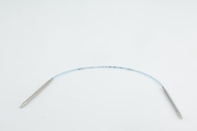 A medical device featuring a flexible, transparent tube with metal connectors at both ends, placed on a plain white background. The tube includes printed measurements or markings along its length, reminiscent of the precision found in Skacel's Addi Turbo Circular Knitting Needles.