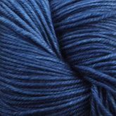 Close-up image of tightly wound Malabrigo Sock yarn by Malabrigo Yarn, showcasing various shades of dark and light blue Merino wool, creating a textured and detailed view of the fibers.