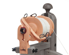 A Schacht Matchless Bulky Plyer Flyer Package from Schacht Spindle Co., loaded with white yarn, features a wooden spinning wheel with various components including a tension knob, hooks, and a vertical support, with the brand "Schacht" engraved on one of the wooden parts.