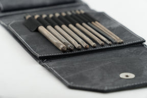 A close-up image of the Lykke 6" Crochet Hook Set in a grey faux denim case by Knitting Fever / Euro Yarns. The crochet hooks, organized in individual slots, vary in sizes and shapes. The open case is laid flat, showcasing the tools as if they come with a lifetime guarantee.