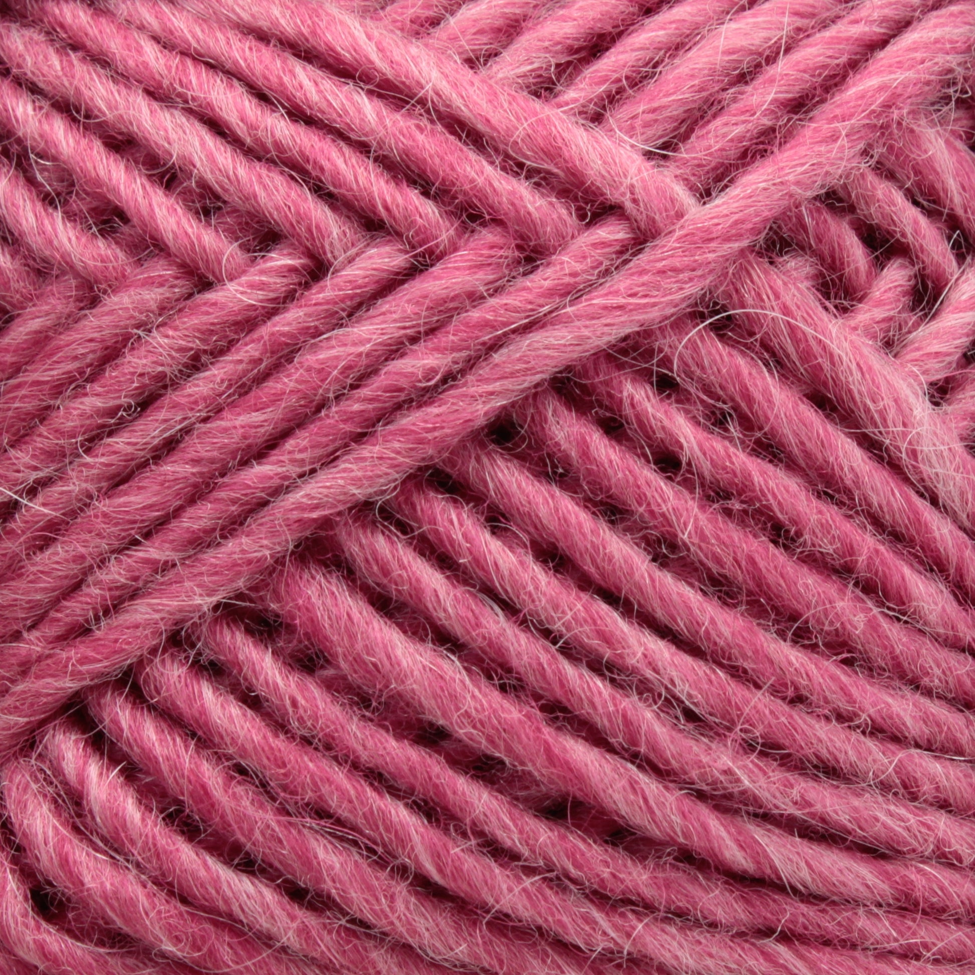 Close-up image of a ball of pink Brown Sheep Lamb's Pride Worsted Yarn. The strands are thick, with a soft, fuzzy texture, tightly coiled together in a neatly organized pattern. Ideal for felting projects, the consistent color gives it a vibrant, cozy appearance.